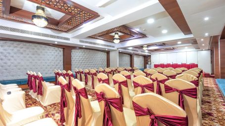 saket hall consisting of multiple decorated  chairs - The Saibaba Hotel