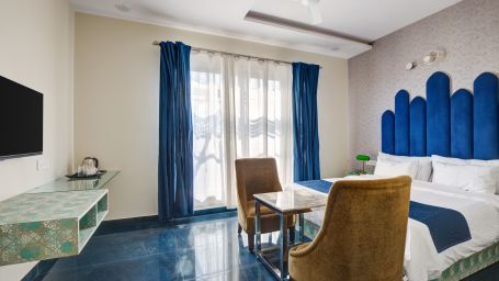 Blue themed Superior Deluxe Room with chairs and LED TV - The White Moon