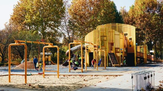 Kids playing  with all the play equipment during mid day 