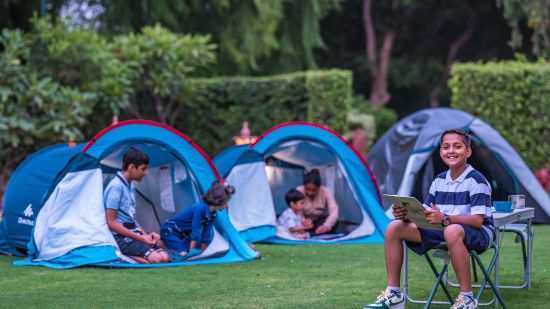 children playing in tents in the lush garden at Heritage Village Resort & Spa, Manesar