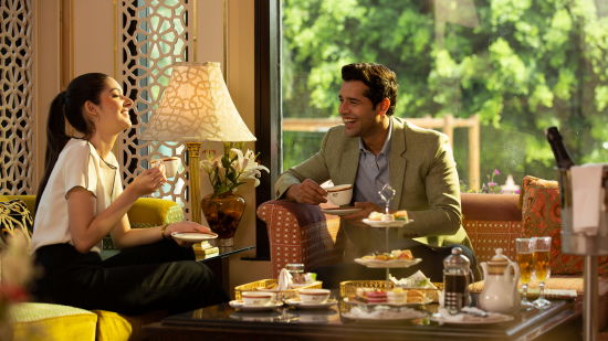 A couple enjoying snacks and tea sitting at the restaurant laughing and sharing a moment - Heritage Village Resort & Spa, Manesar