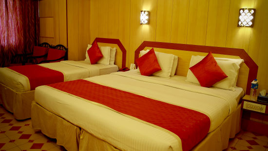 a view of a room furnished with a double bed and a single bed - Hotel Swagath, Bangalore