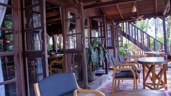 tables at a beachside restaurant in Goa - Wave's entrance and surrounding trees shot during daytime - Lotus Eco Beach Resort Benaulim Goa