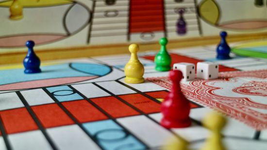 a closer view of a ludo board with pawns and dice on it