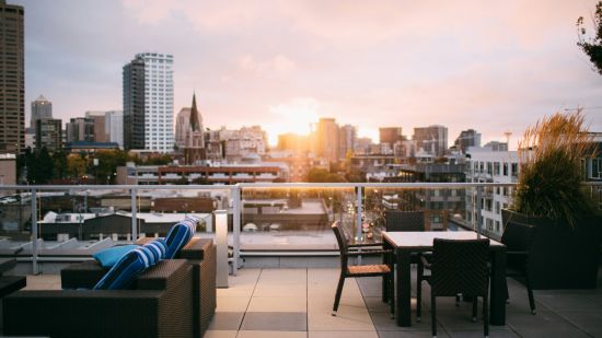 an overview of the seating arrangements inside a rooftop restaurant with the sun setting in the background