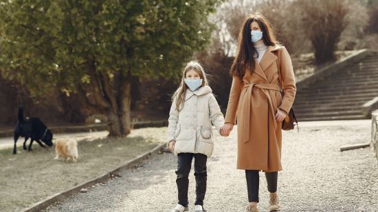 mother-with-daughter-in-face-masks-walking-in-park-4000622