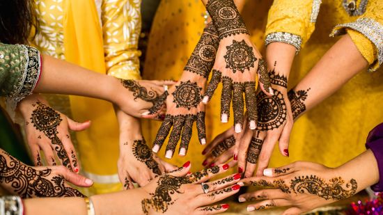 many women showing their hands after henna application on hand as pre-wedding ritual 