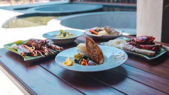 a table with different foods on a plate - Symphony Samudra Beachside Jungle Resort And Spa