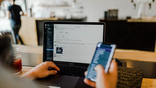 A person using a laptop and phone