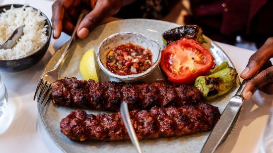 a plate of kebabs served to a diner