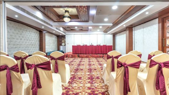 A big banquet hall  with multiple decorated  chairs - The Saibaba Hotel