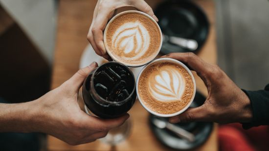 3 people holding cups of different hot and cold coffees 