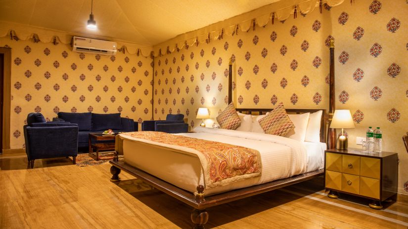 The interiors of our tent suites in Pushkar with a bed, a sofa set and tasteful decor 