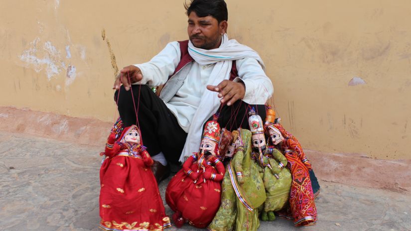 person sitting with colourful puppets