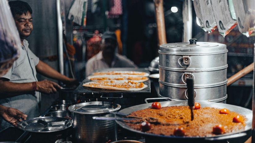 an image of a momo steamer and a tawa with an indian dish being prepared