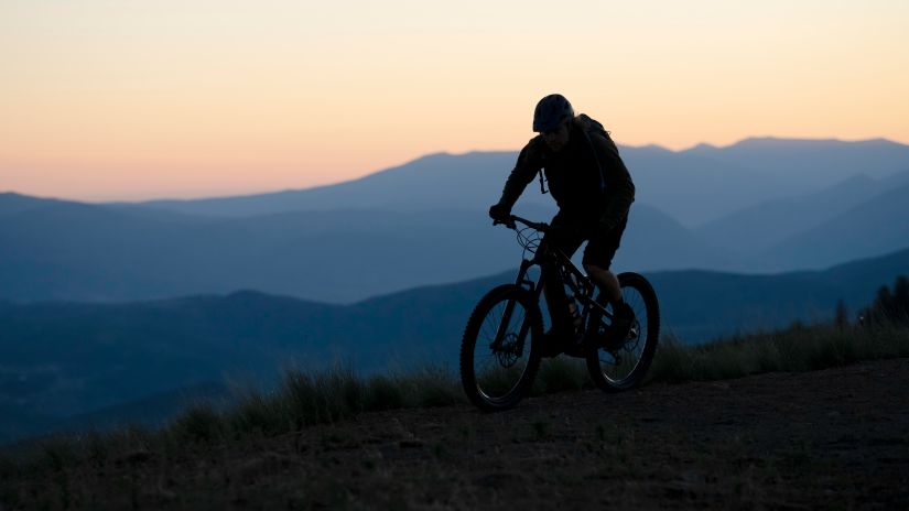 young adult using an electric bike for cycling on a country side during sunset