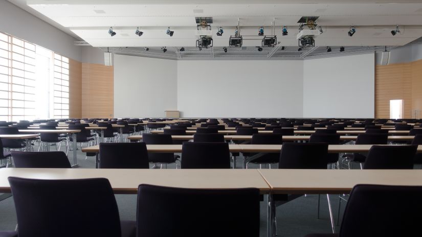 An empty meeting room with chairs lined up next to each other