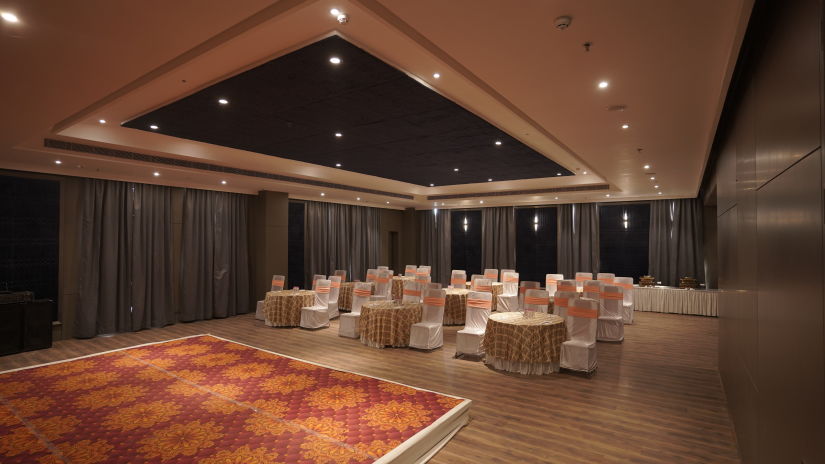 banquet hall decorated with a stage, tables and chairs at Classic Sapphire by Ananta