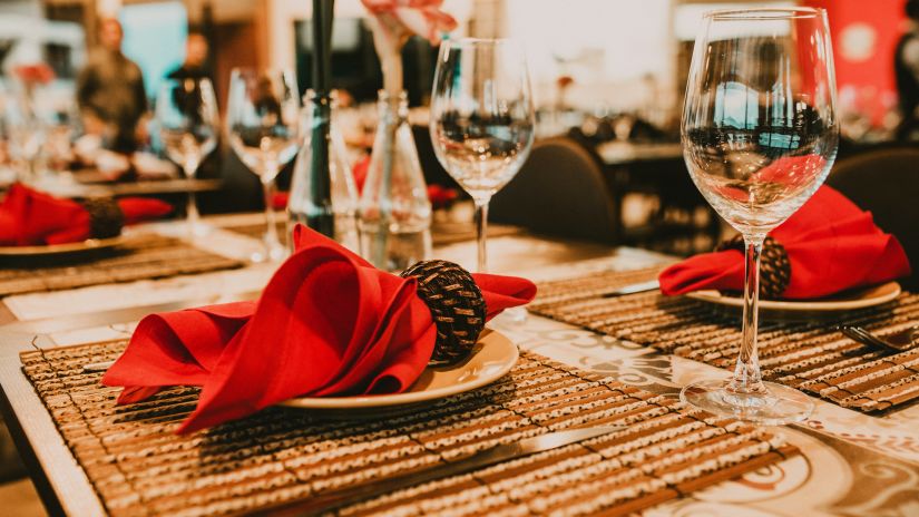 Side view of a red napkin kept on a table along with wine glasses