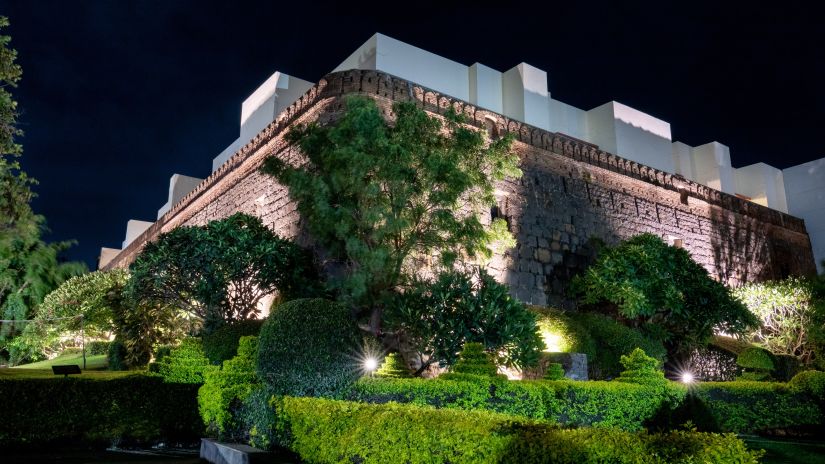 Magnificent building of Fort Jadhavgadh Heritage hotel with garden in Pune