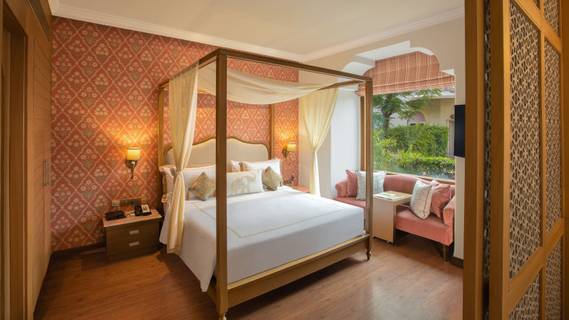 luxurious room with a commodious king size bed and cushy sofa designed with plush interiors