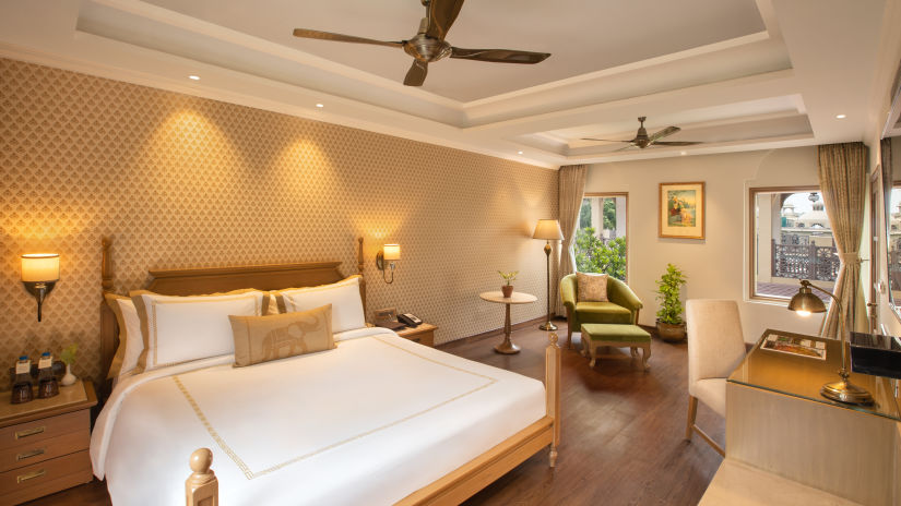 suite in manesar with a comfy king size bed, lavish interiors and wooden flooring at heritage village resort and spa
