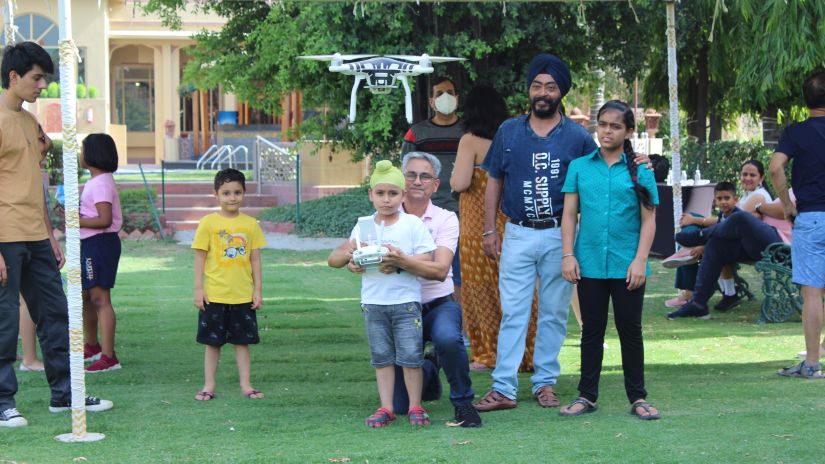 Heritage Village Resorts Manesar - image of an instructor helping a child fly a drone