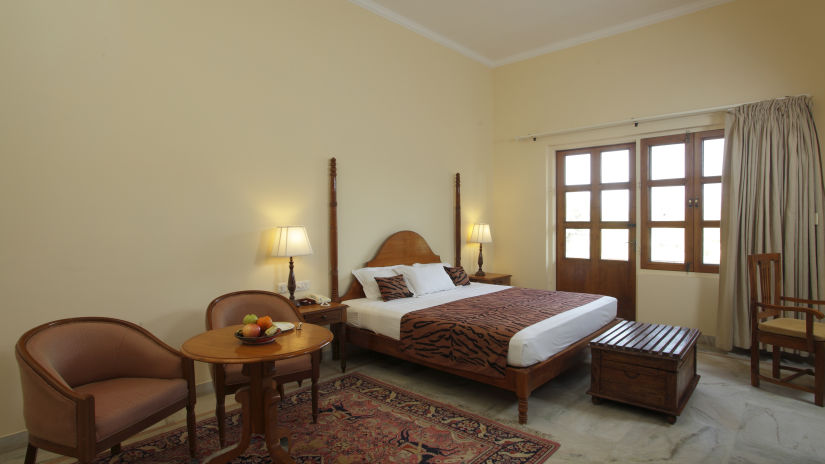 the bedroom comprising a bed and single sofas at Standard Suites in Ranthambore
