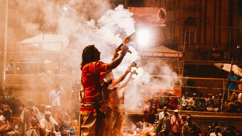 Men stand amidst a crowd holding chalices with smoke coming out of it