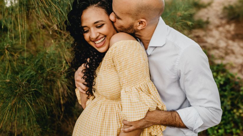 A man kisses and embraces his pregnant wife - Babymoon Near Delhi