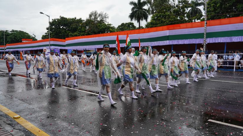 a group of young girls on a parade wearing uniforms and raincoats