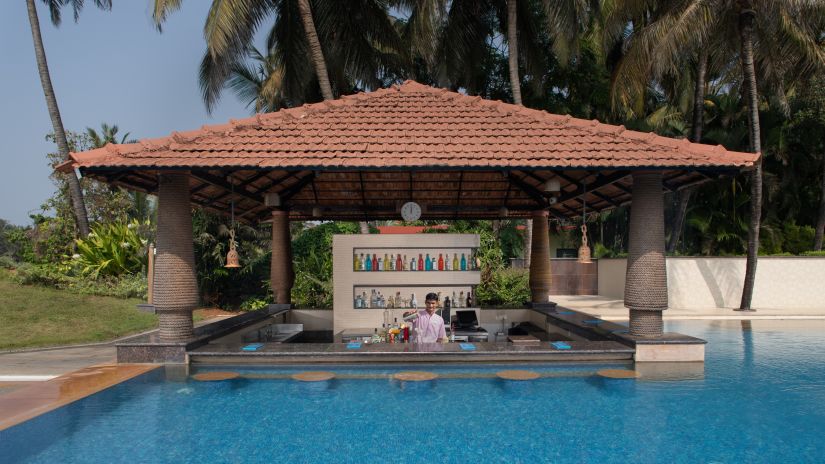 Our pool-side cafe in South Goa, Aquarius, looks dream-like as it resembles a gazebo coming out of the pool in a lush green backdrop