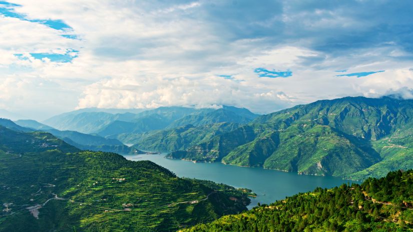 the panoramic view of green valleys with clouds floating above