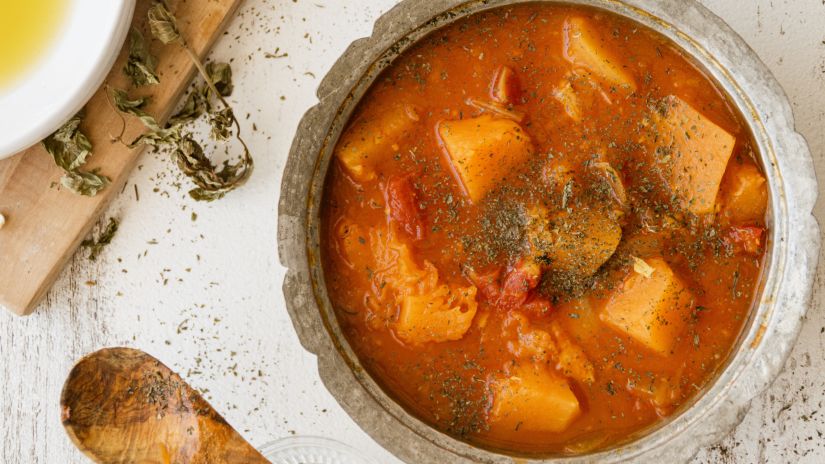 Gravy served on a bowl and the wooden spoon is kept aside.