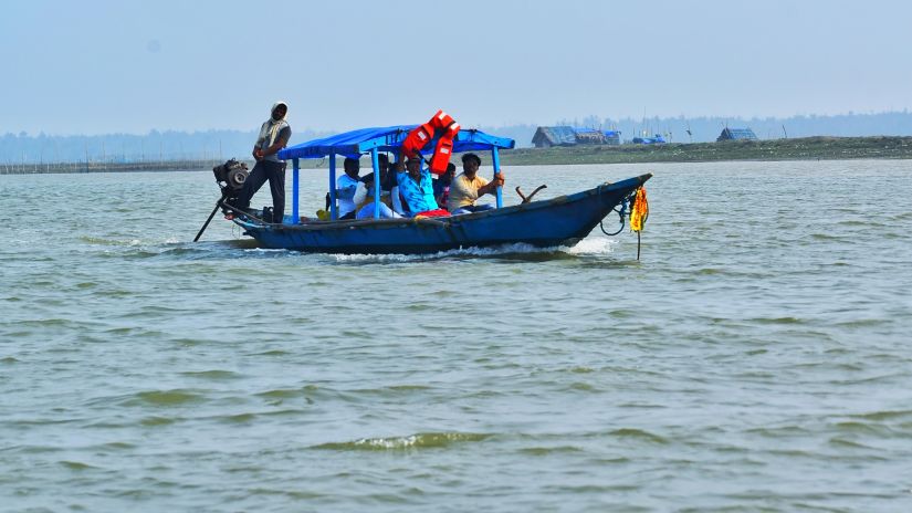 people sailing on the ocean in a blue and black boat during daytime