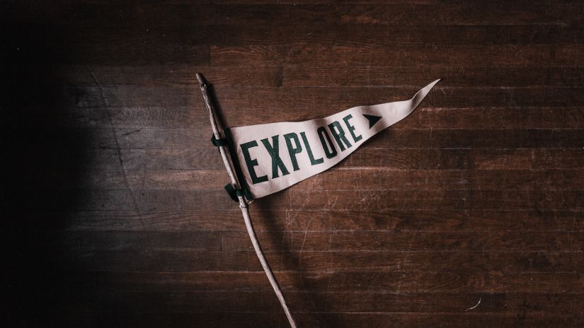 Explore written in a cloth on a wooden poll