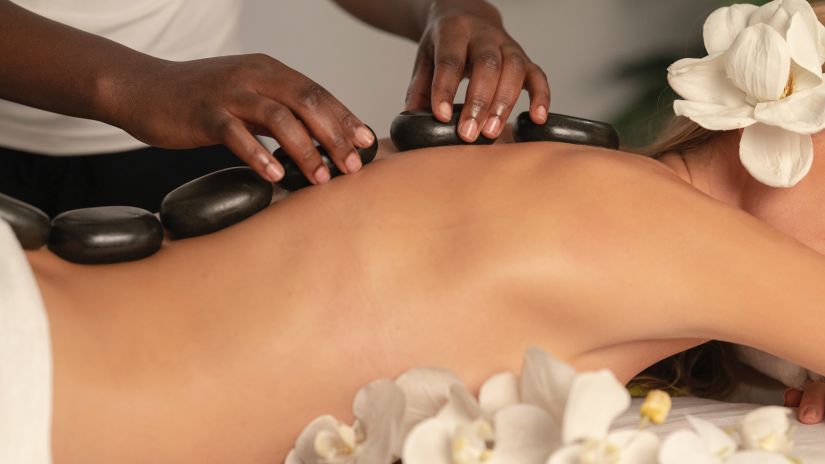 a woman getting a hot stone massage at a spa