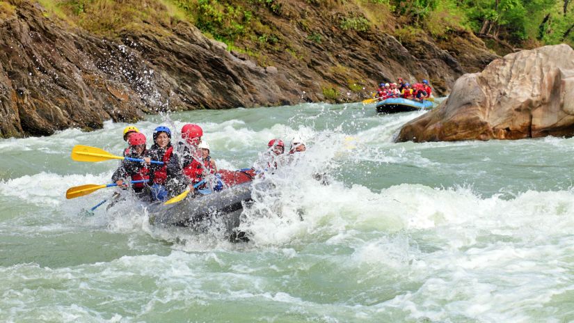 a group of people rafting in the waters of Rishikesh