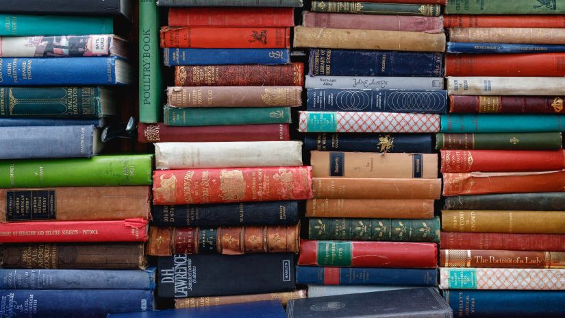 books stacked on each other and kept on racks 