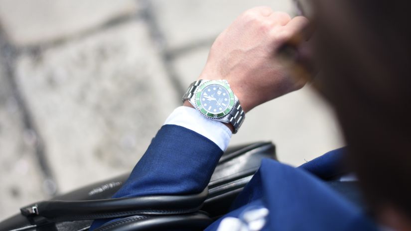 a person looking at their watch with the pavement in the background