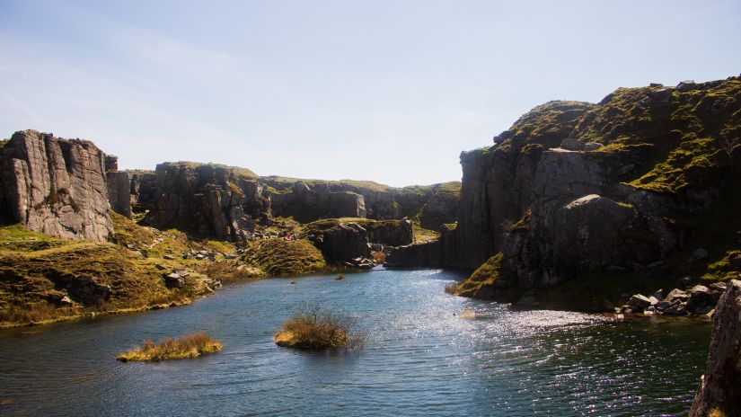 a Lake surrounded by rocks and blue sky above it