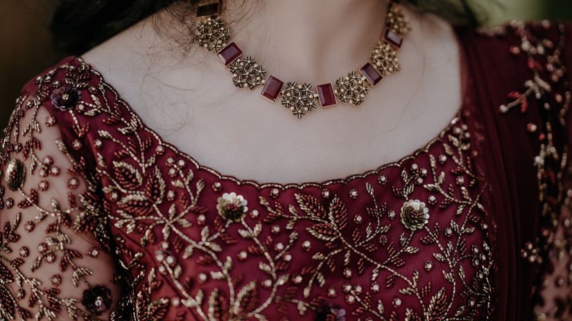 a close up shot of a Woman wearing traditional style necklace