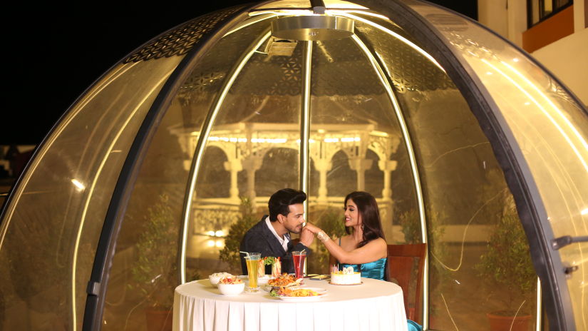 a bubble kind of dome with a table for two and couple inside celebrating - Shanti Seaview Resort & Spa