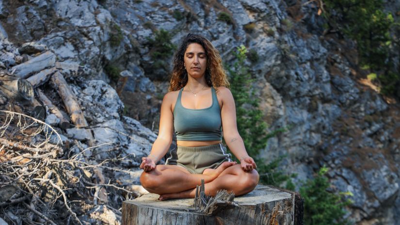 A girl meditating sitting on a stone