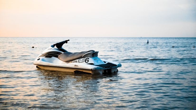 a solitary jet ski in the ocean with the evening sky in the background