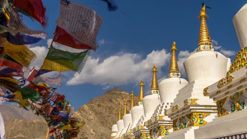 white coloured Buddhist monestry with colourful flags