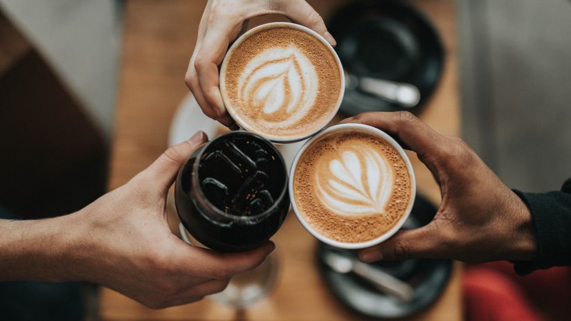 three people holding coffee mugs together