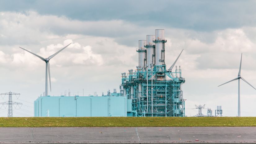 a blue and white factory with windmill during daytime