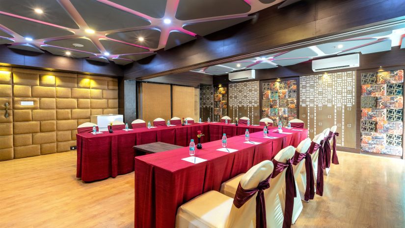 A spacious hall with several chairs and tables - The Saibaba Hotel