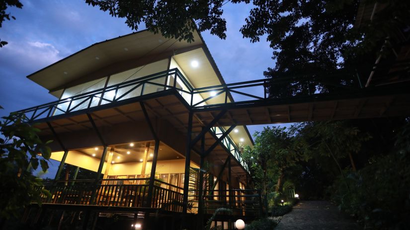 exterior of one of the cottages at The Sal Woods Forest Resort & Spa around sunset